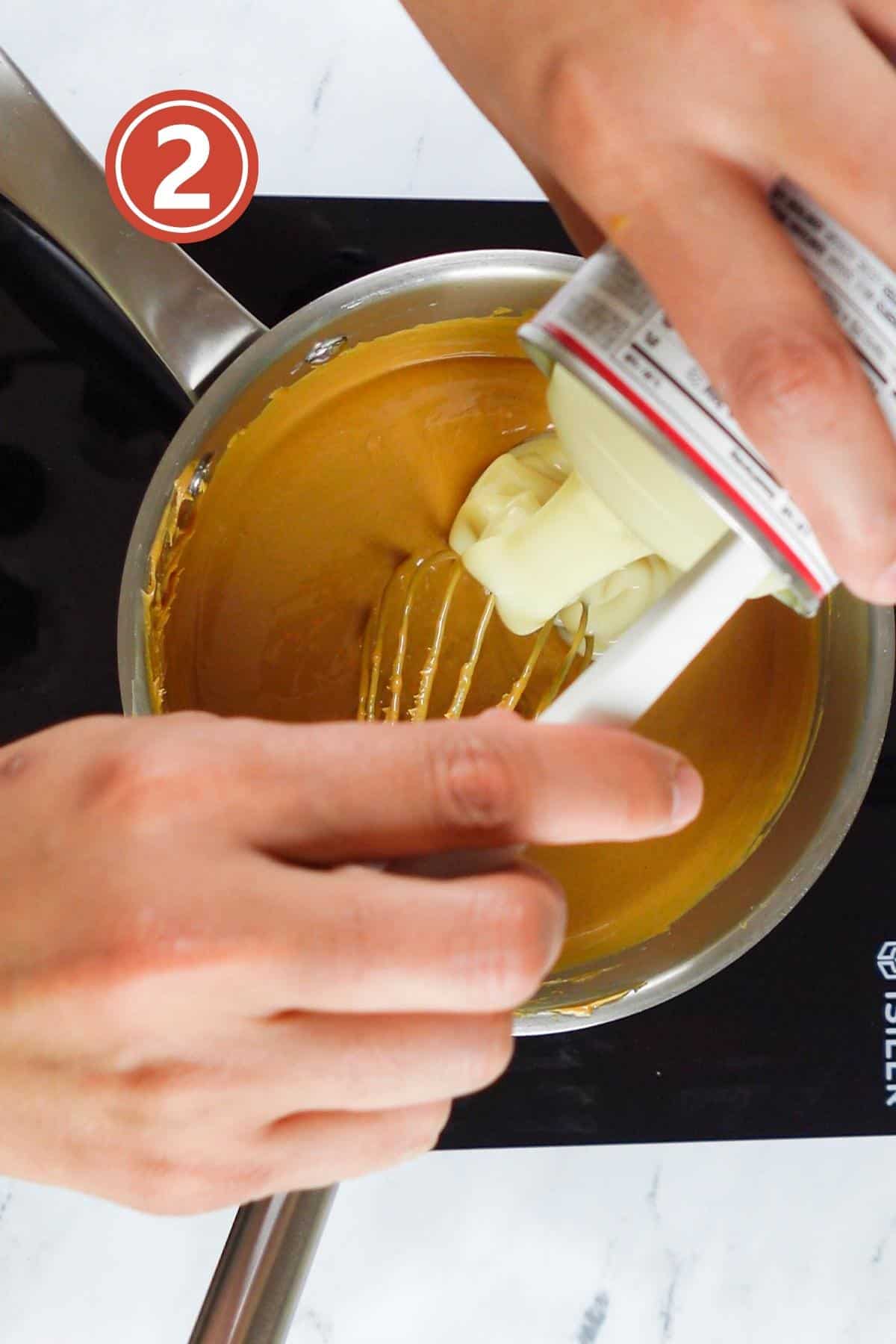 adding condensed milk to the melted peanut butter in the saucepan.