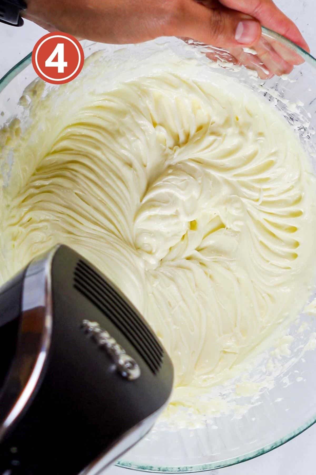 beating the cream cheese and sugar in a large bowl for strawberry crunch cheesecake.