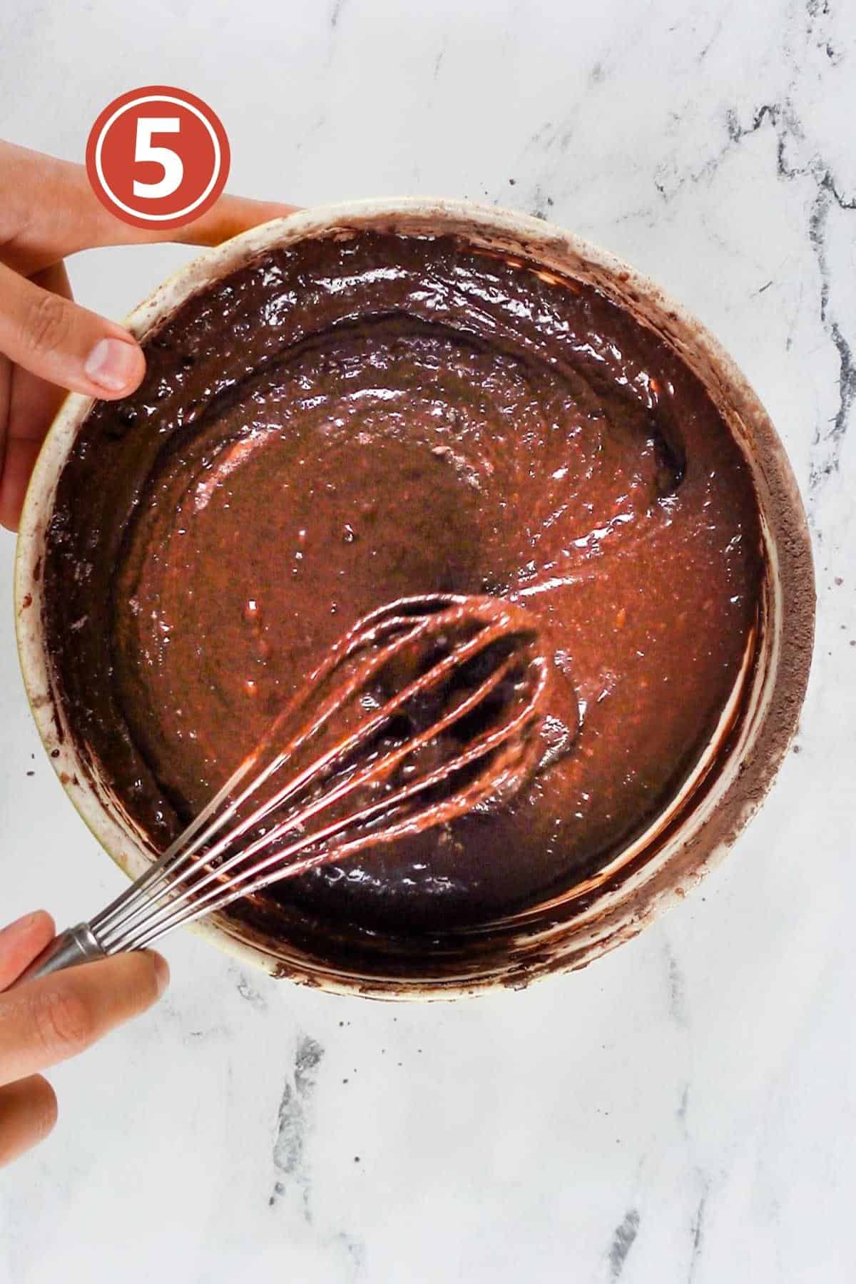 Mixing the dry ingredients into the wet ingredients into the brownie batter.