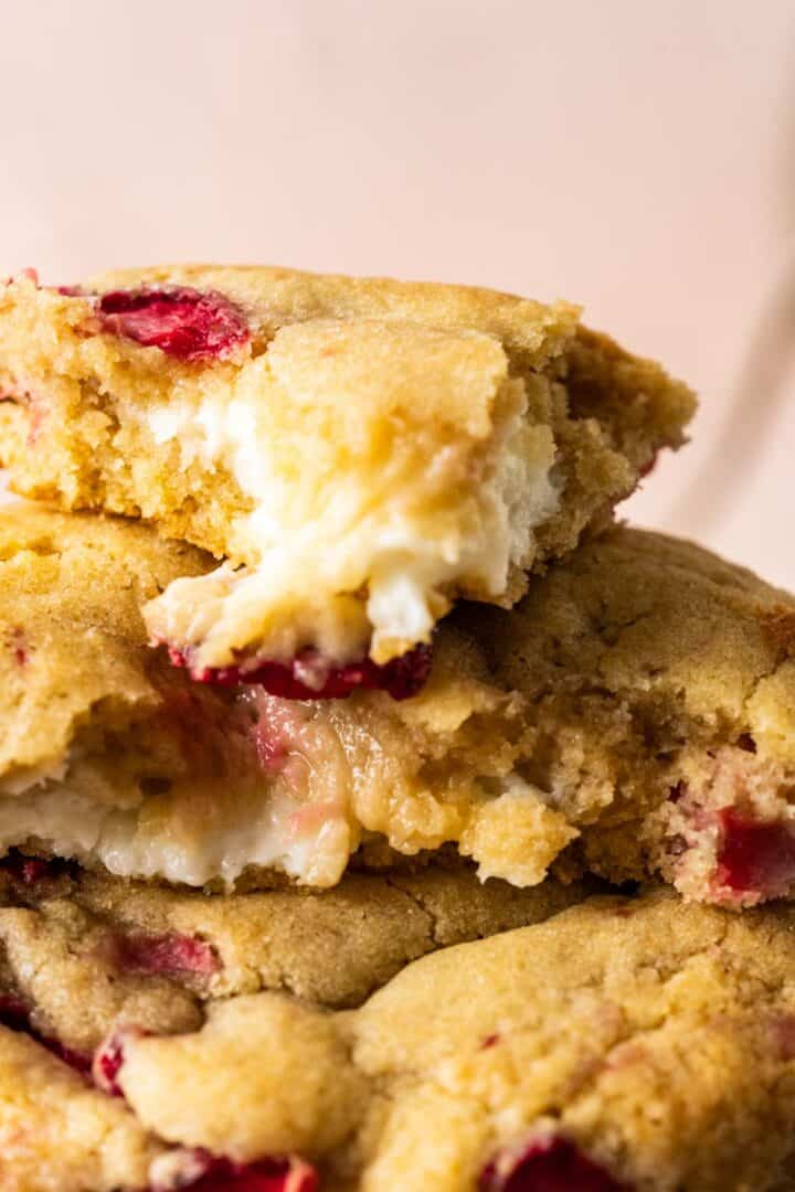 close shot of one cookie showcasing cheesecake filling inside.