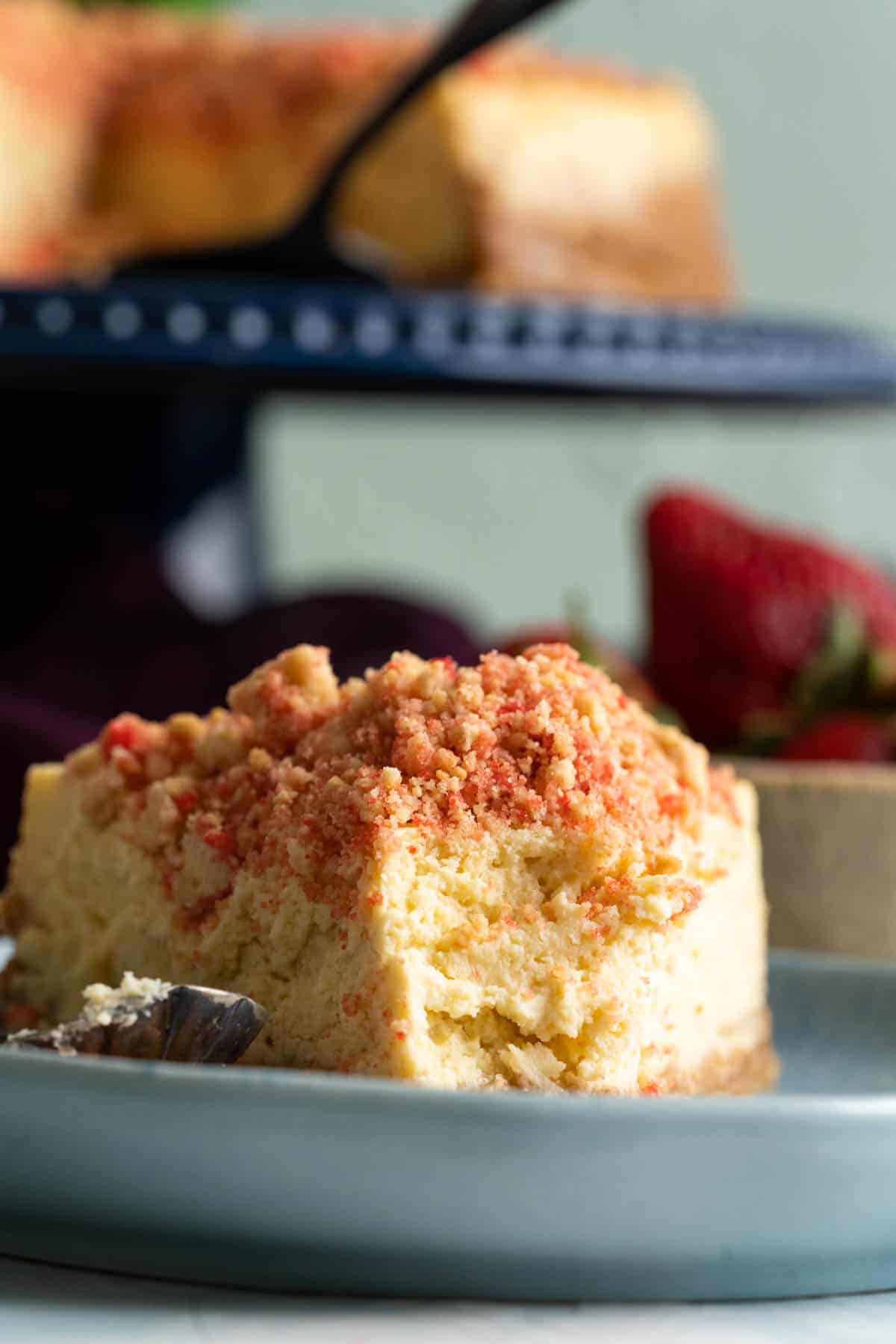 a slice of creamcheese on a blue plate showing the texture of the cake closely.