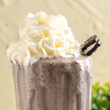 banana oreo milkshake with an oreo biscuit on the side.