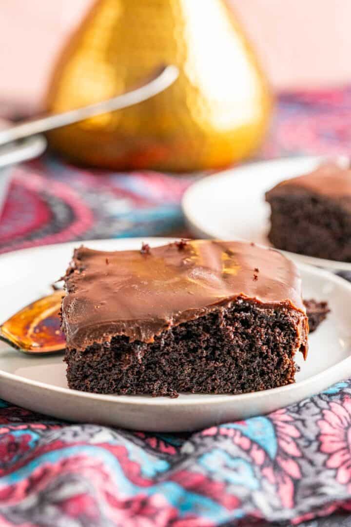 one piece of chocolate cake with chocolate ganache in a white plate.