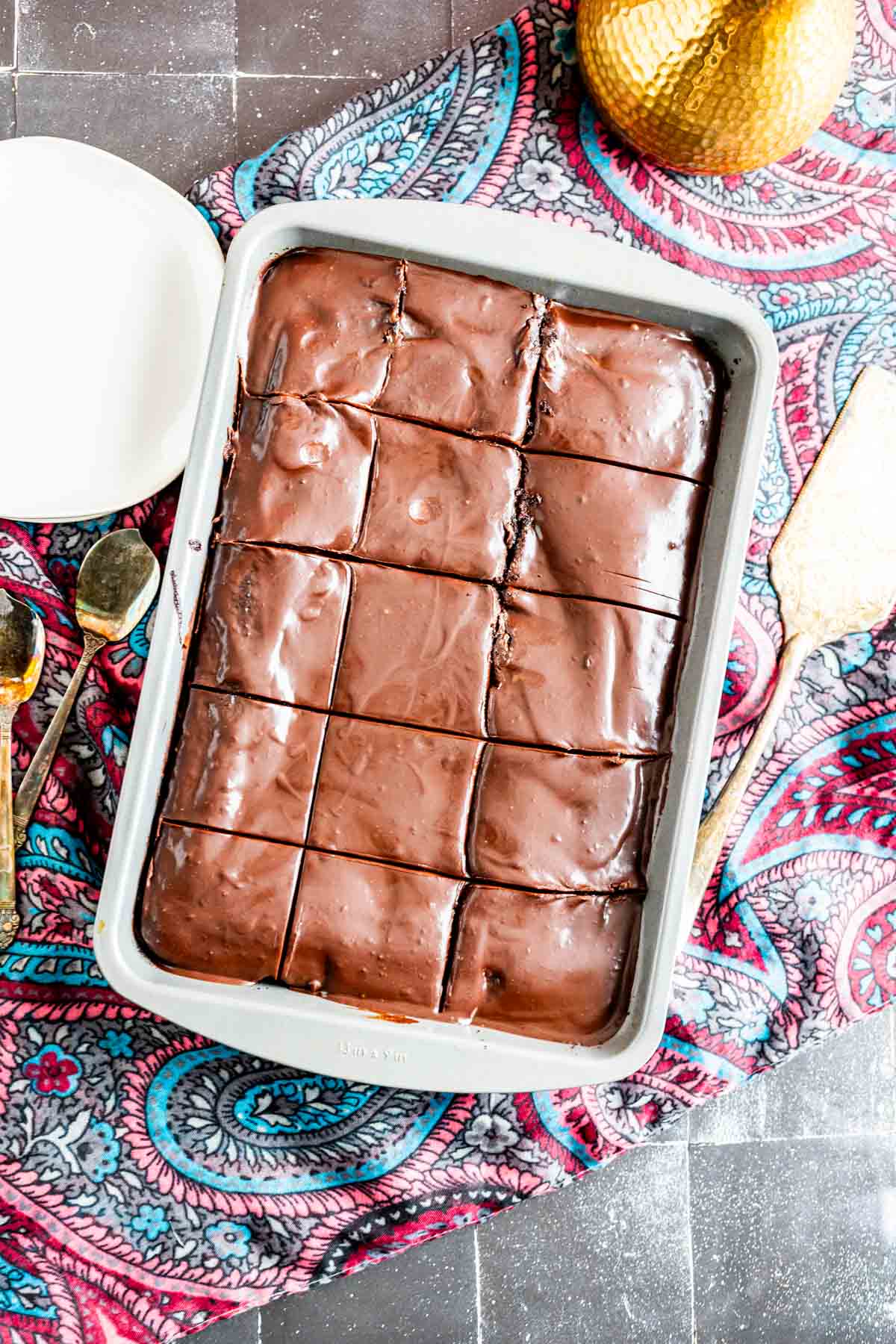 Chocolate cake with mayonnaise placed on a colorful table cloth.