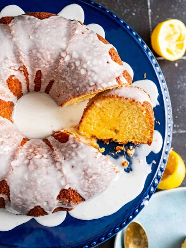 overhead shot of the lemon yogurt cake with a cut slice on the side placed on the black table.