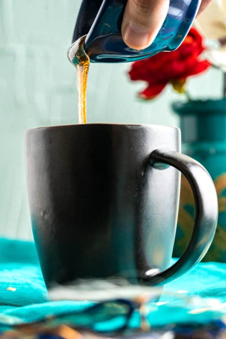 pouring honey from a blue small bowl over the mug cake.