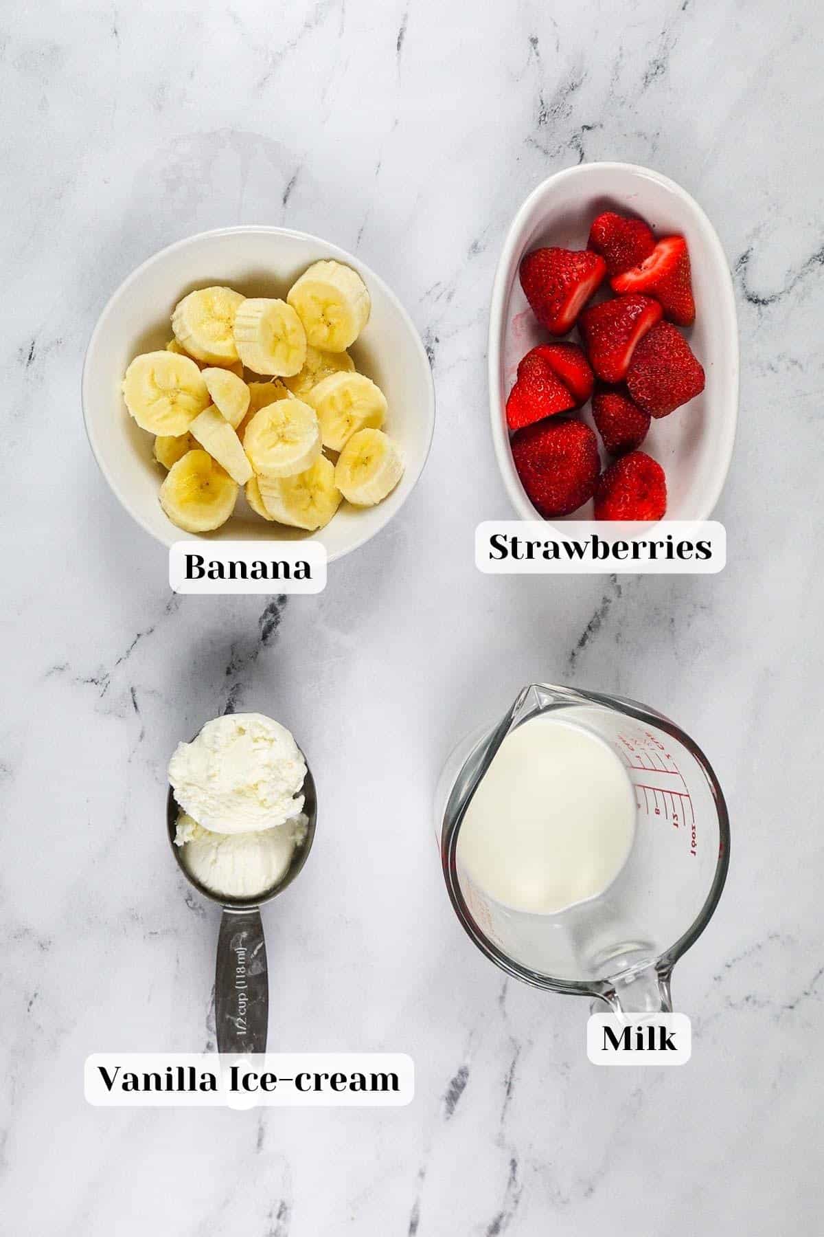 Ingredients for strawberry banana milkshake placed on the table.