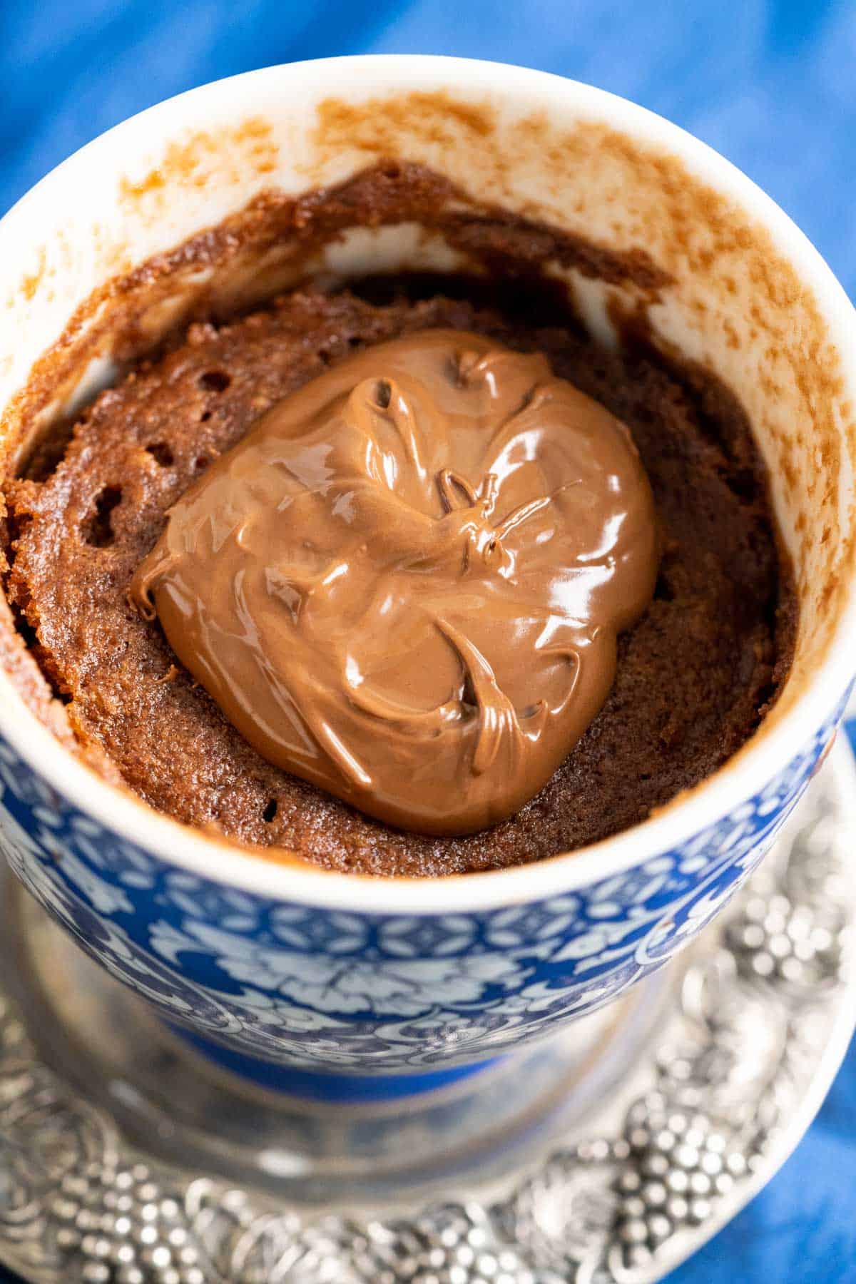 A dollop of nutella placed on nutella mug cake. 