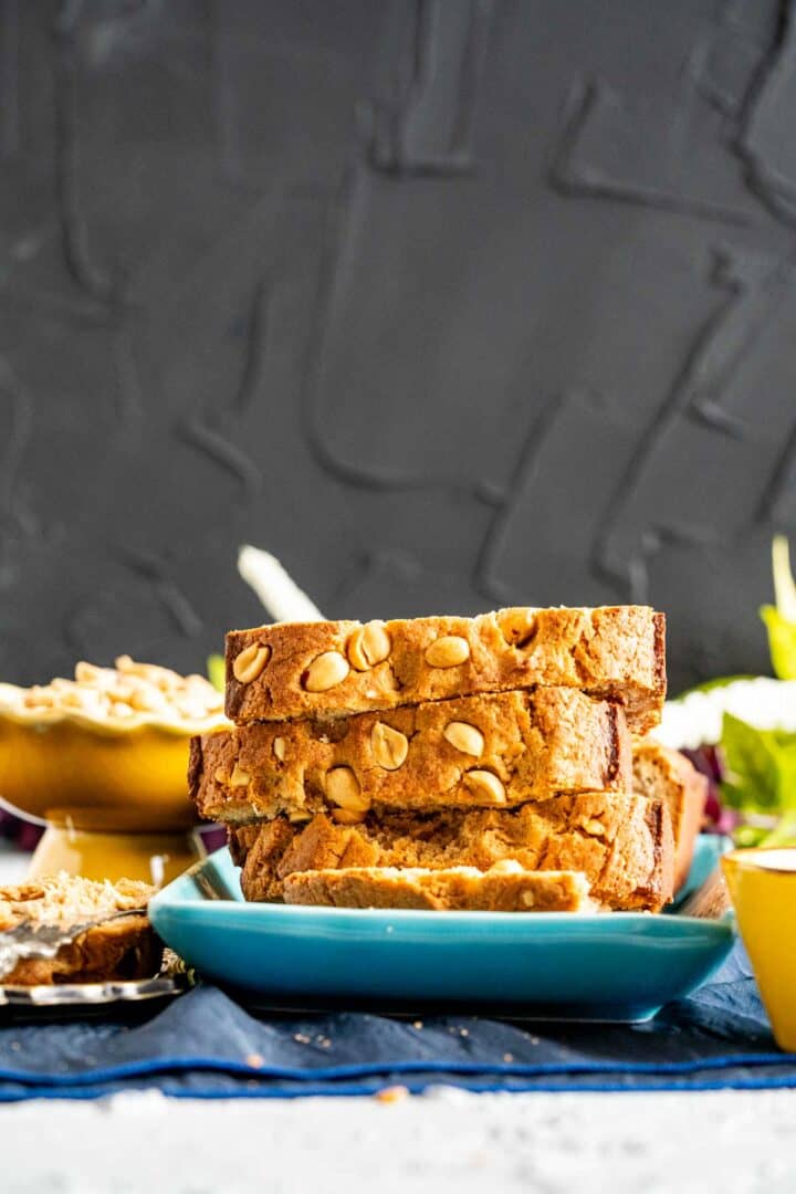 close shot of the quick bread with peanuts in a yellow stand in the backdrop.