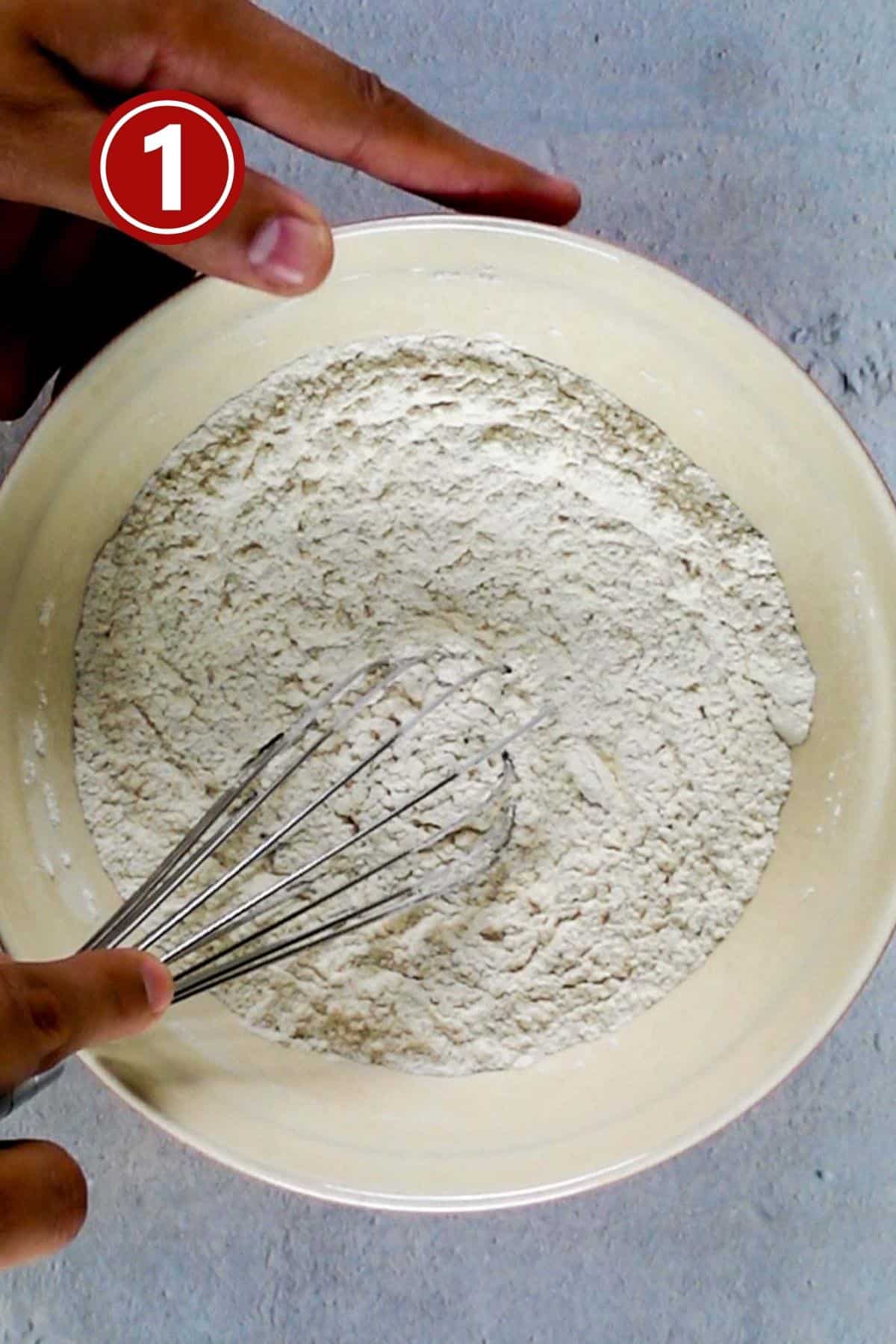 Whisking the dry ingredients together in a large bowl.