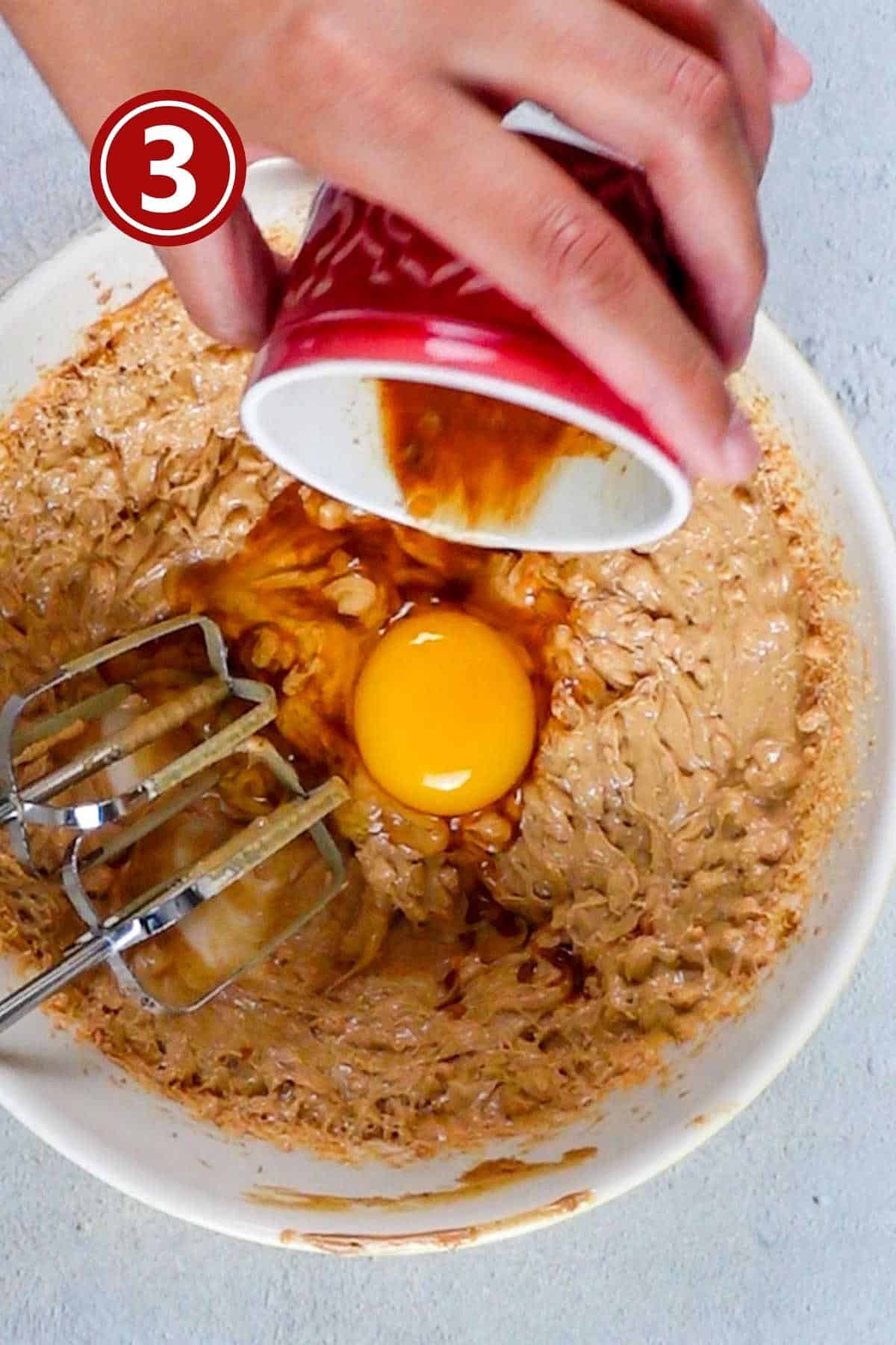 Adding the egg and vanilla extract into the butter and peanut butter mixture.