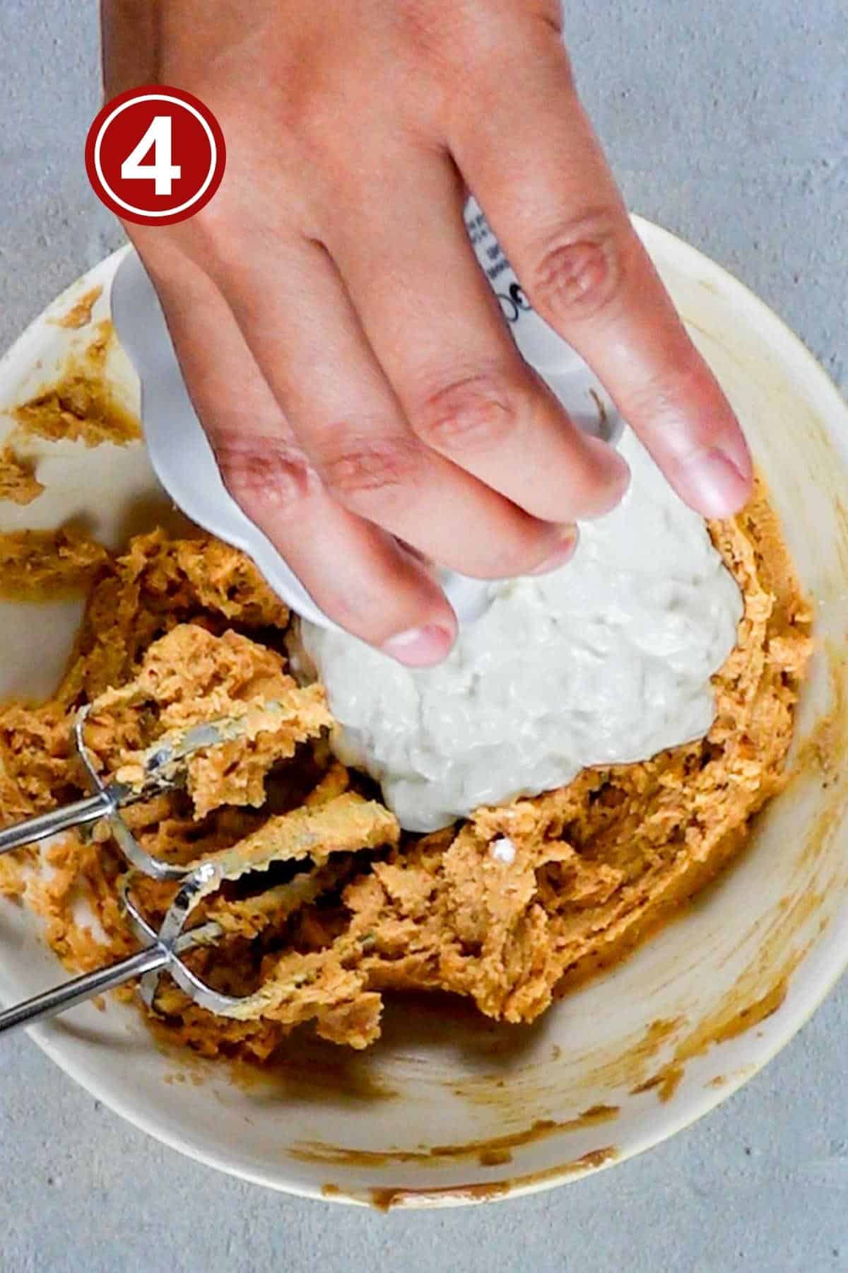 Adding sour cream into the peanut butter bread batter.