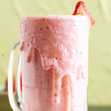 strawberry banana milkshake in a cup.