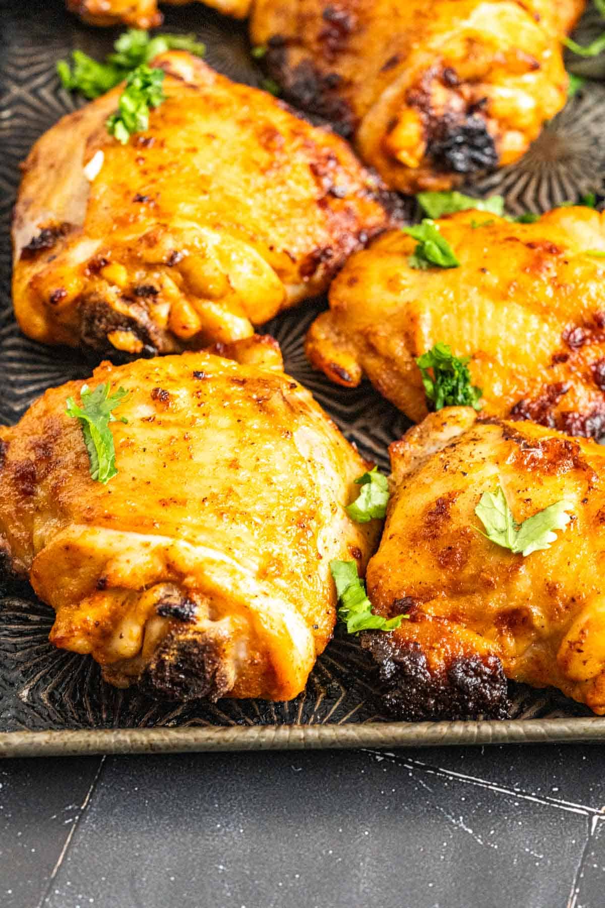 Chicken thighs on an antique silver tray showing the skin and texture.