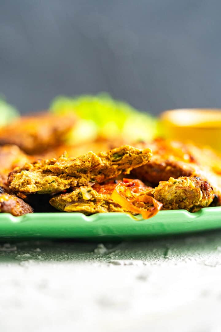 one chapli kabab split in half on the plate.