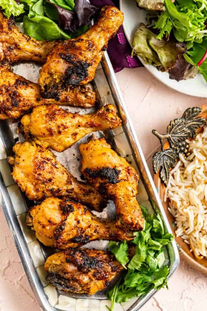 from the top shot of chicken in a plate with parsley on the side and white rice in an antique plate.