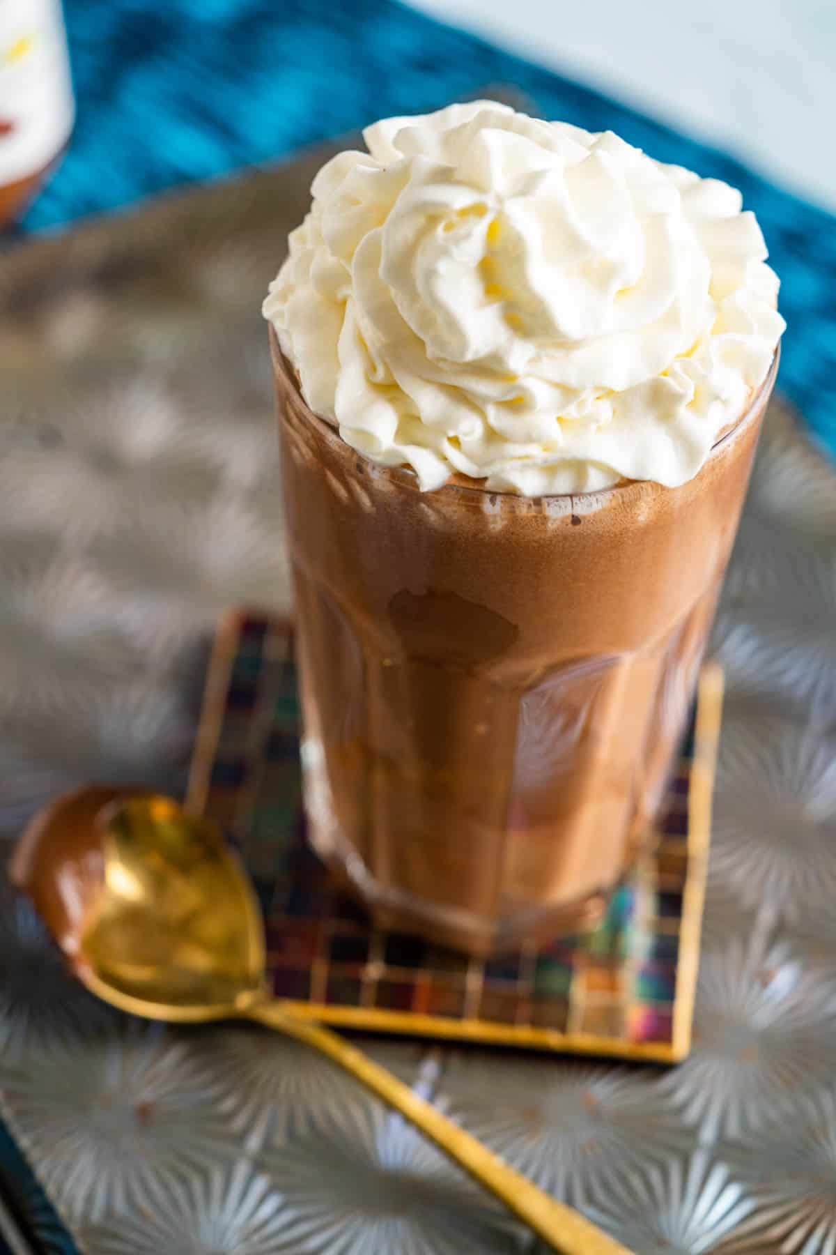 Nutella drink in tall glass with a dollop of whipped cream on the top.