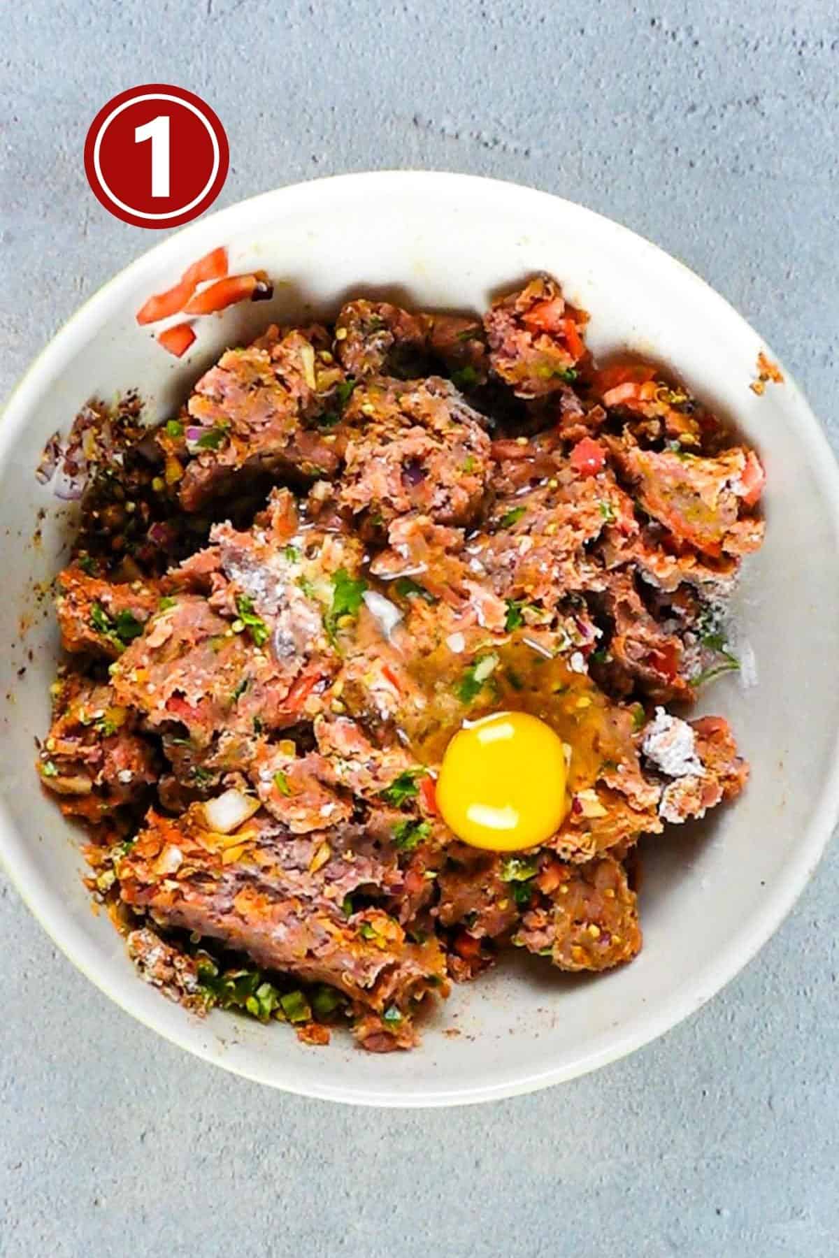 Spices and minced beef in a large bowl for kababs.