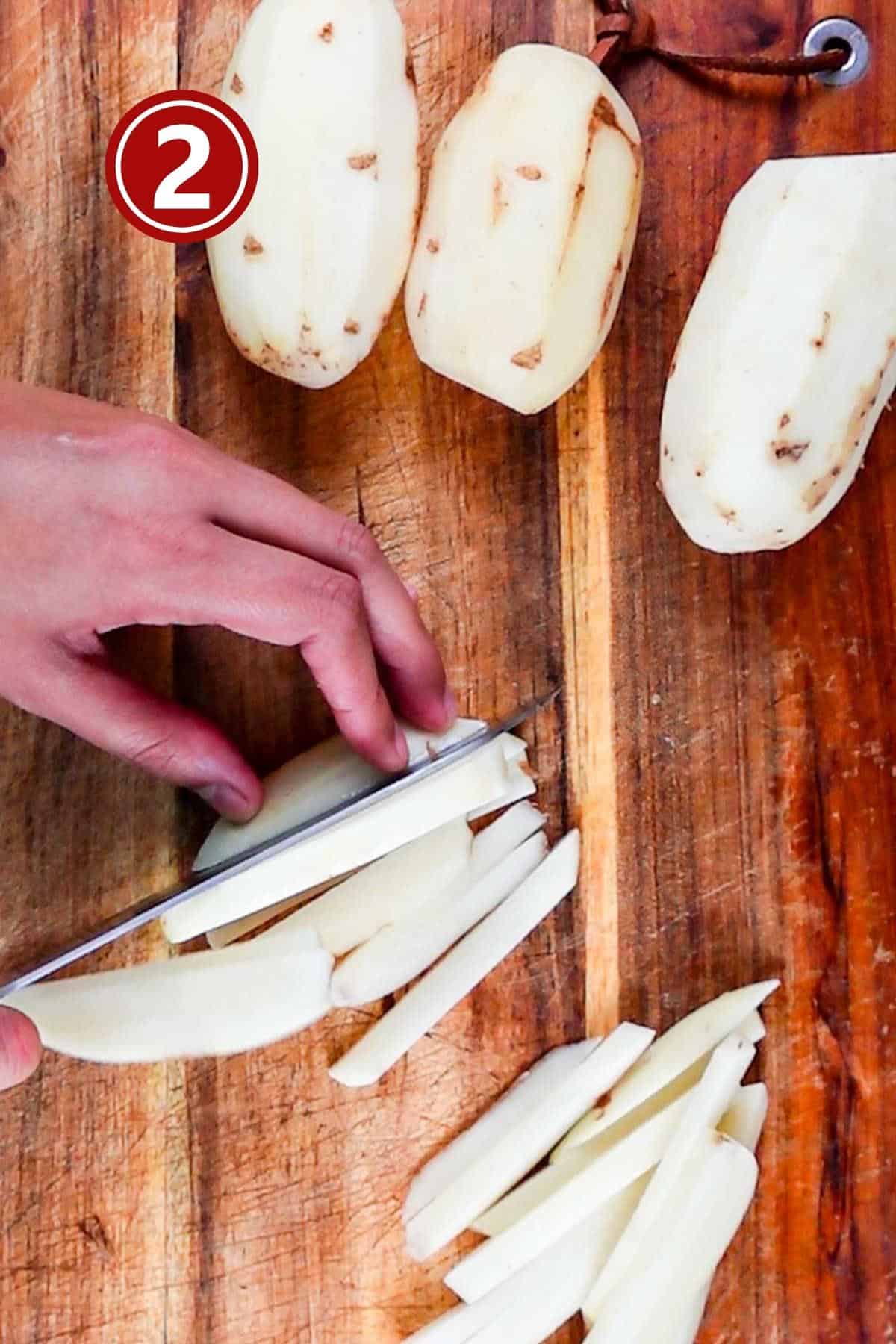 Cutting the fries on a wooden board in even sizes.