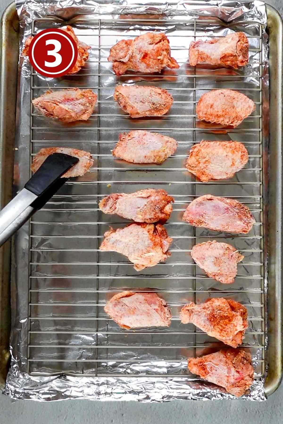 Placing the chicken wings on the baking tray.