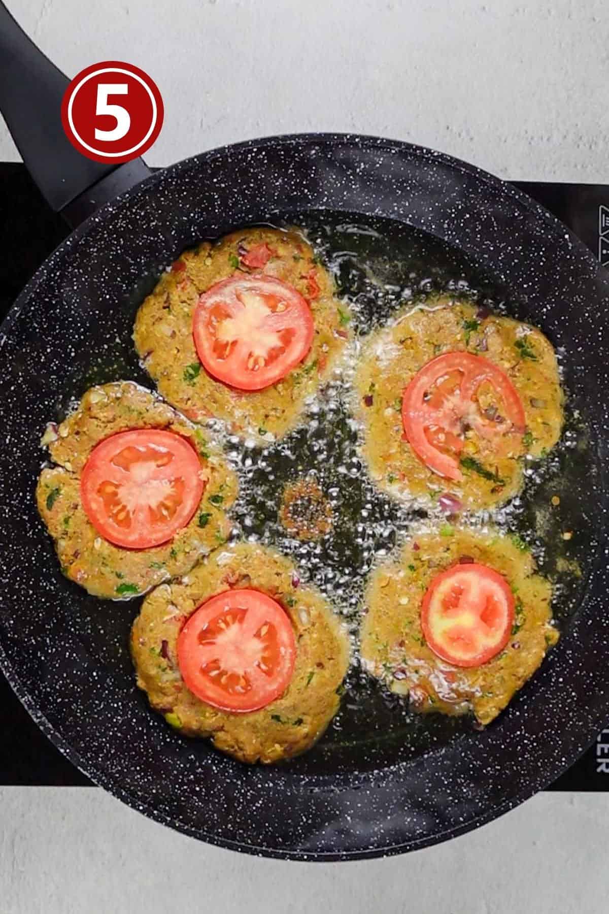 Chapli kababs placed in the frying pan for frying.