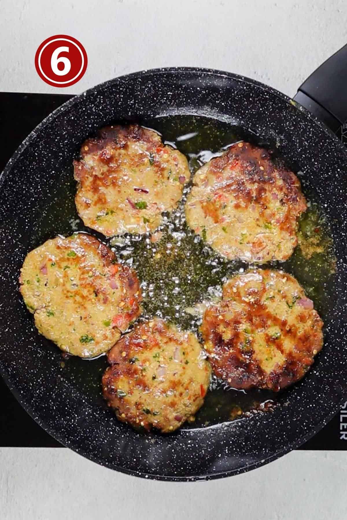 Chapli kabab showing brown exterior from one side during frying.