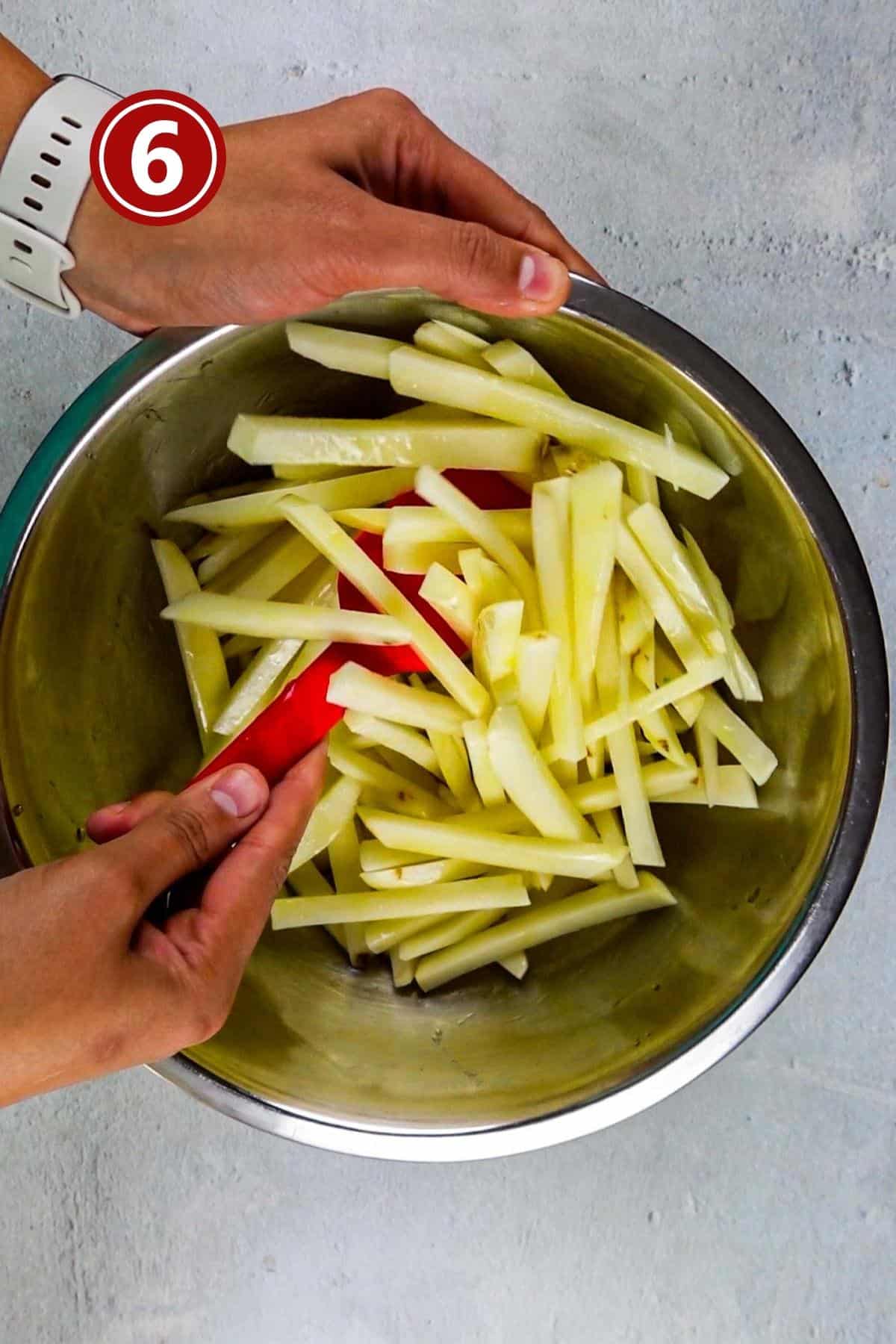 Tossing the fries in the olive oil.