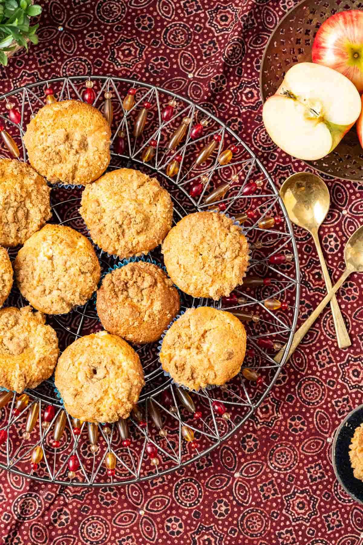 Apple cinnamon muffins on a decorative plate with an apple on the side.