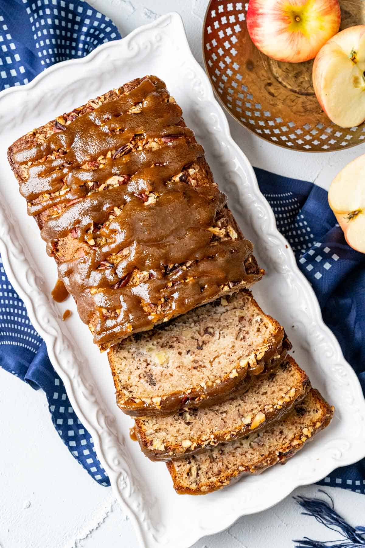 from the top shot of apple praline bread with cut slices in a white plate.