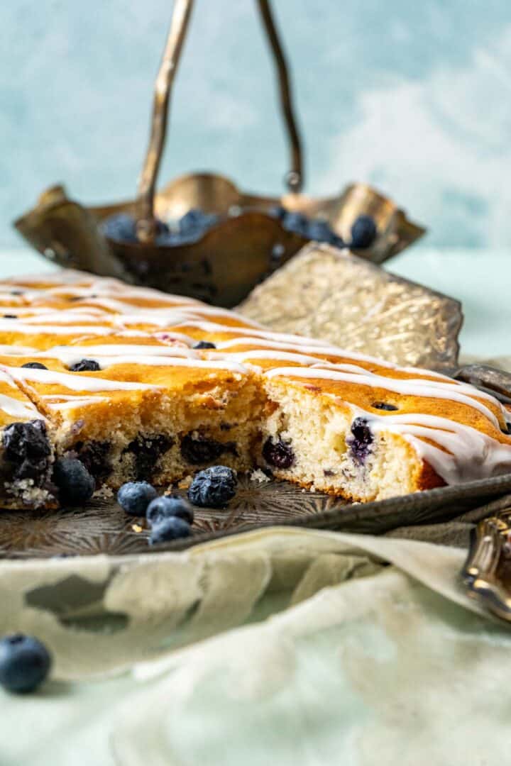 close shot of cake sitting in the tray with blueberries around.