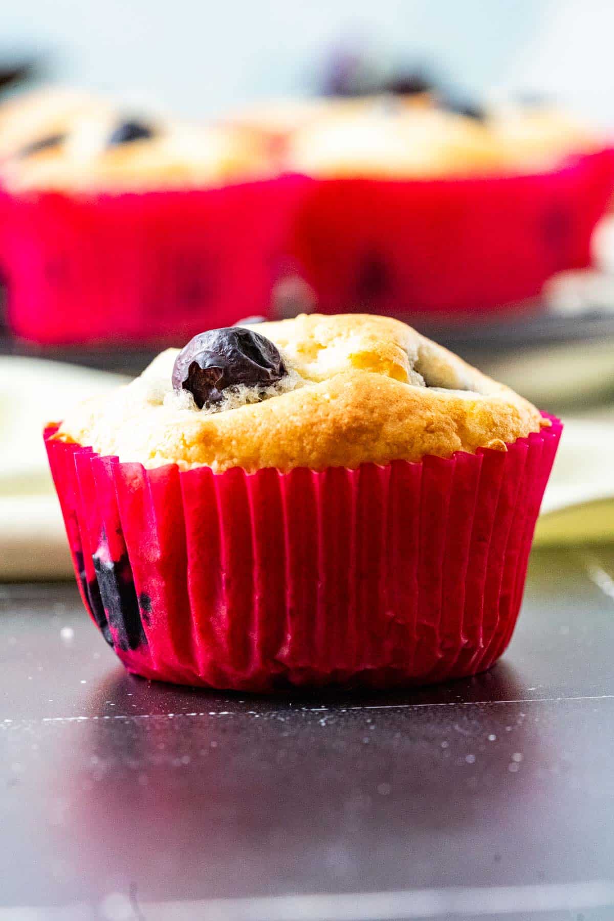 close up shot of a single muffin in red muffin liner.