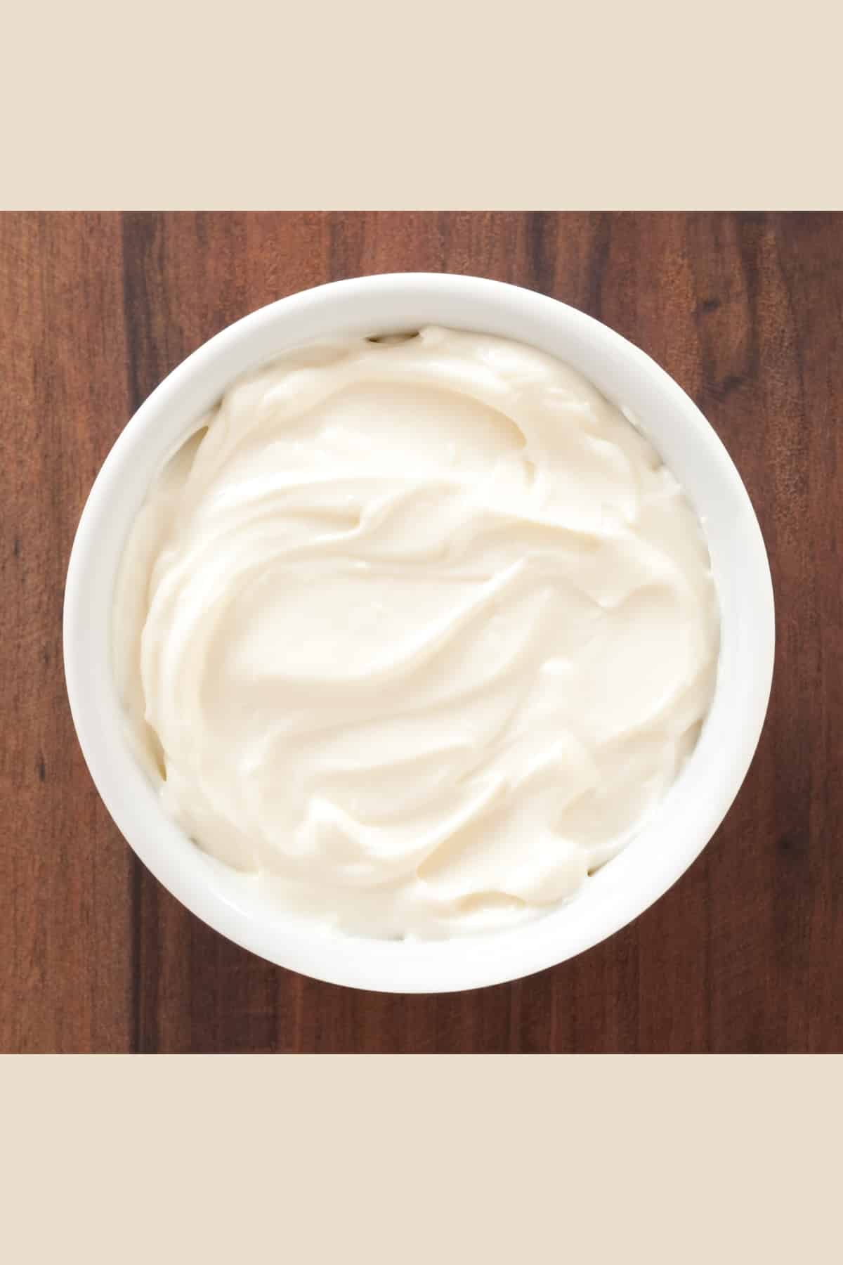 cheese in a white bowl placed on a wooden surface.