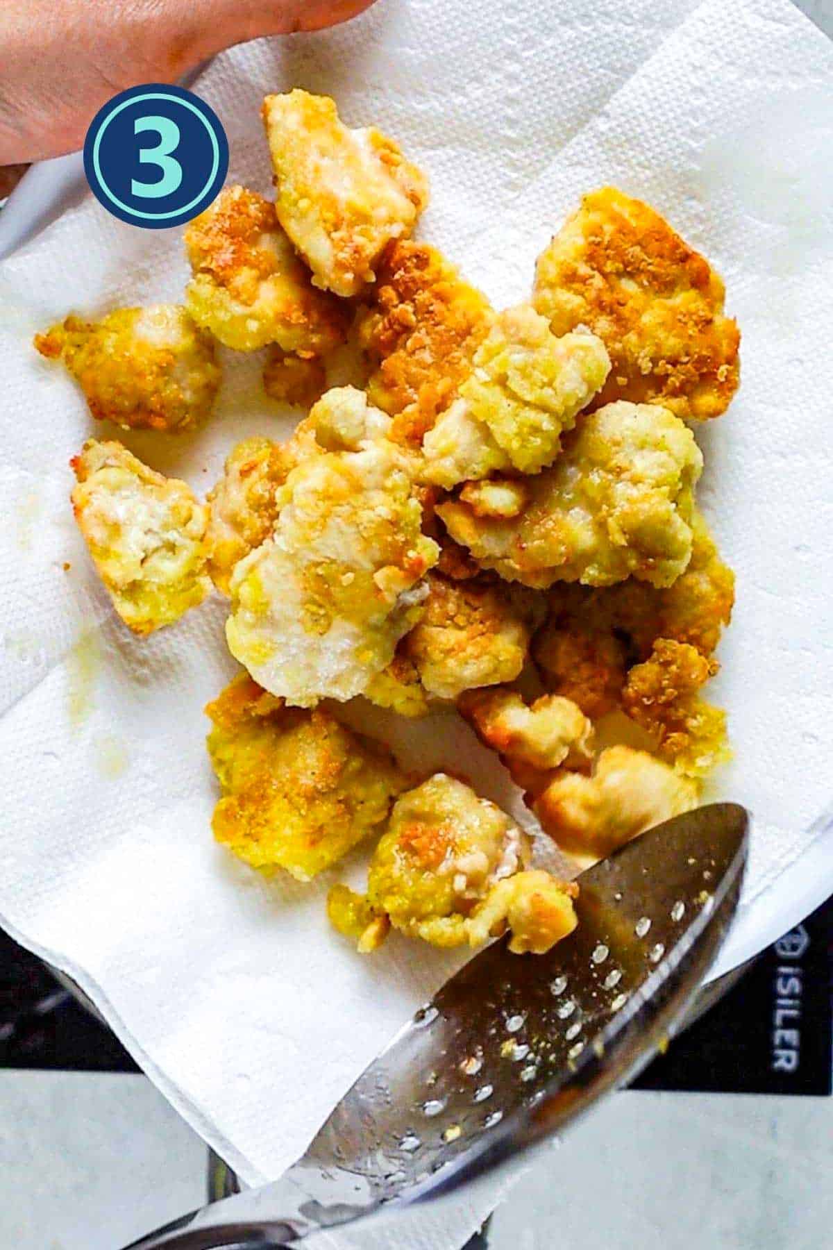 Fried chicken pieces on paper towel in a plate.