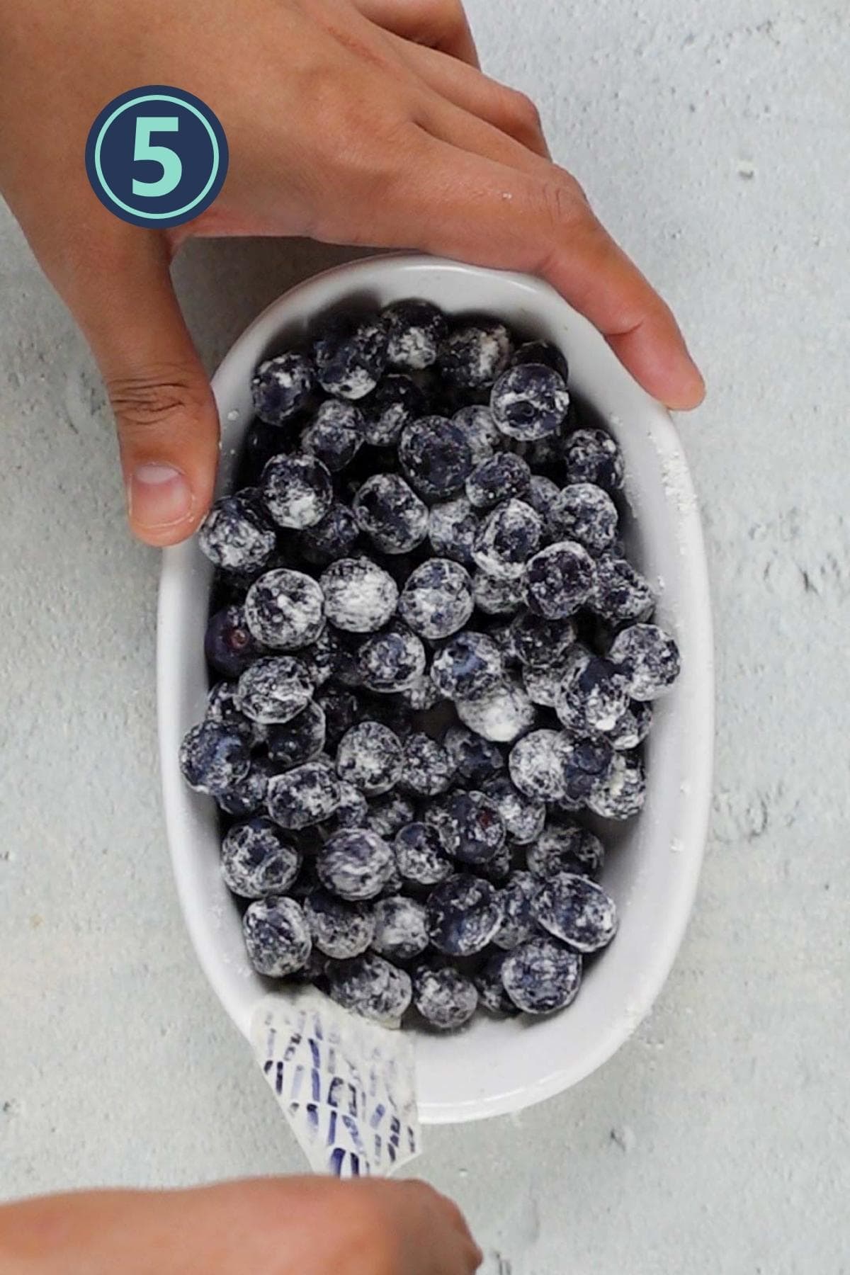 tossing the blueberries in all purpose flour.