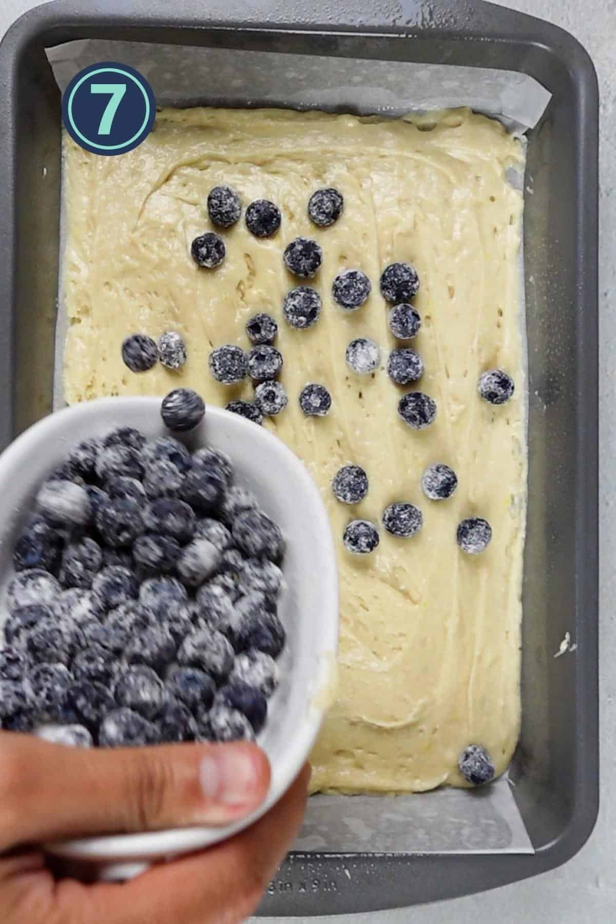 spreading the blueberries onto the cake layer.