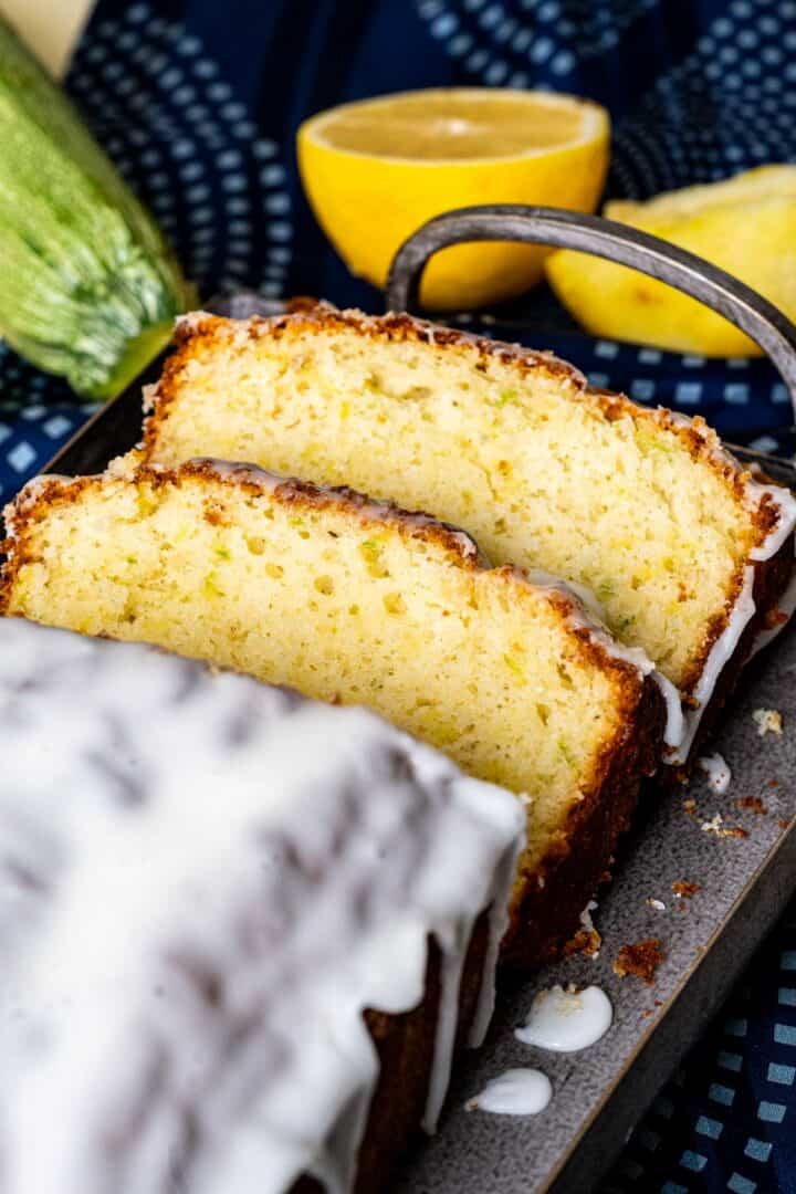 close shot of lemon and zucchini bread slices with a tangy lemon glaze on it.