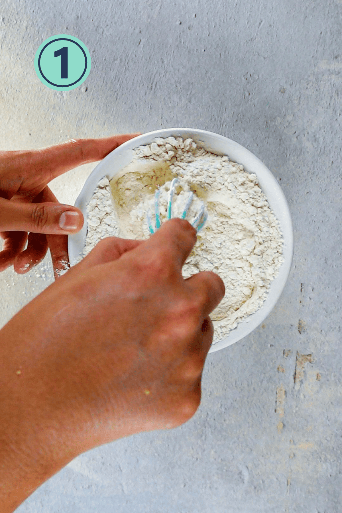 Whisking up dry ingredients for the lemon zucchini bread in a bowl.