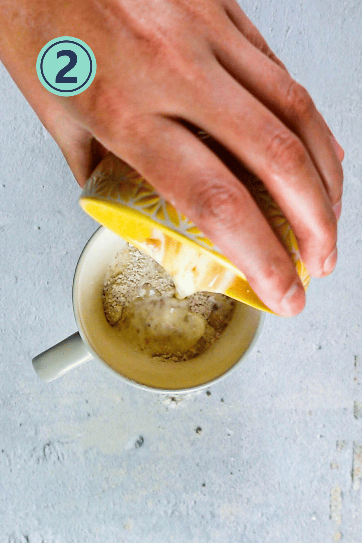 Adding wet ingredients to the dry ingredients for mug cake.