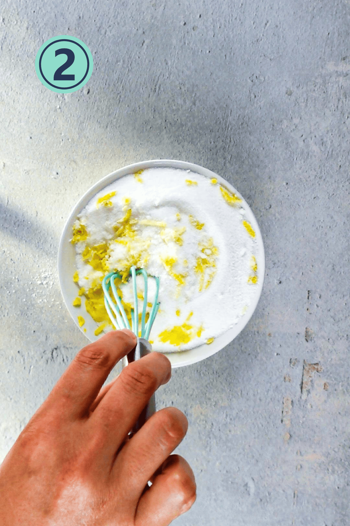 rubbing the lemon zest into the sugar using a whisk.