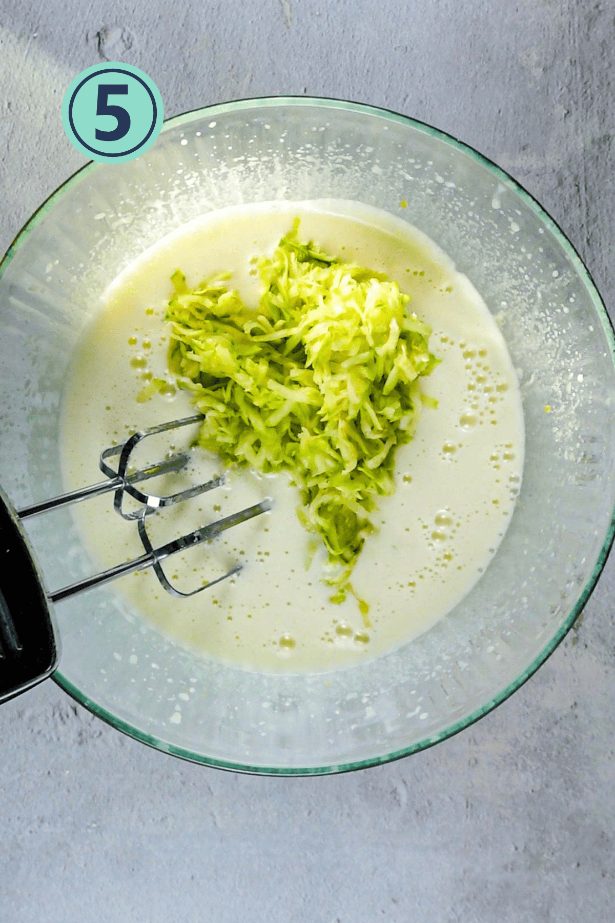 Adding the grated and squeezed out zucchini into the batter.