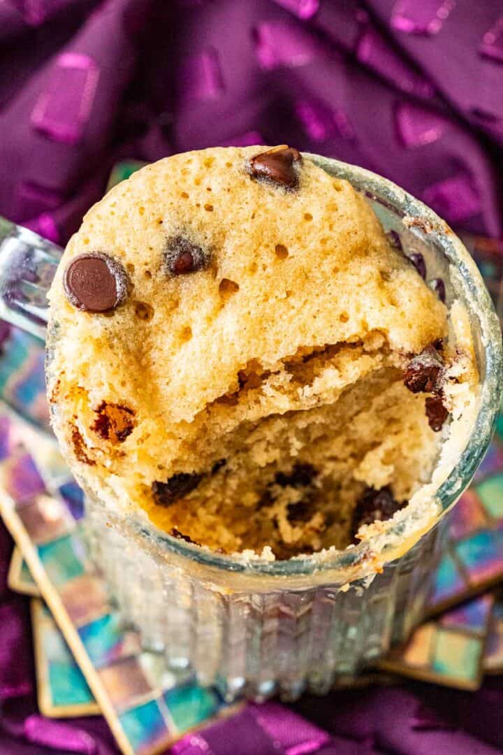 fluffy cake with chocolate chips on the top in a mug.