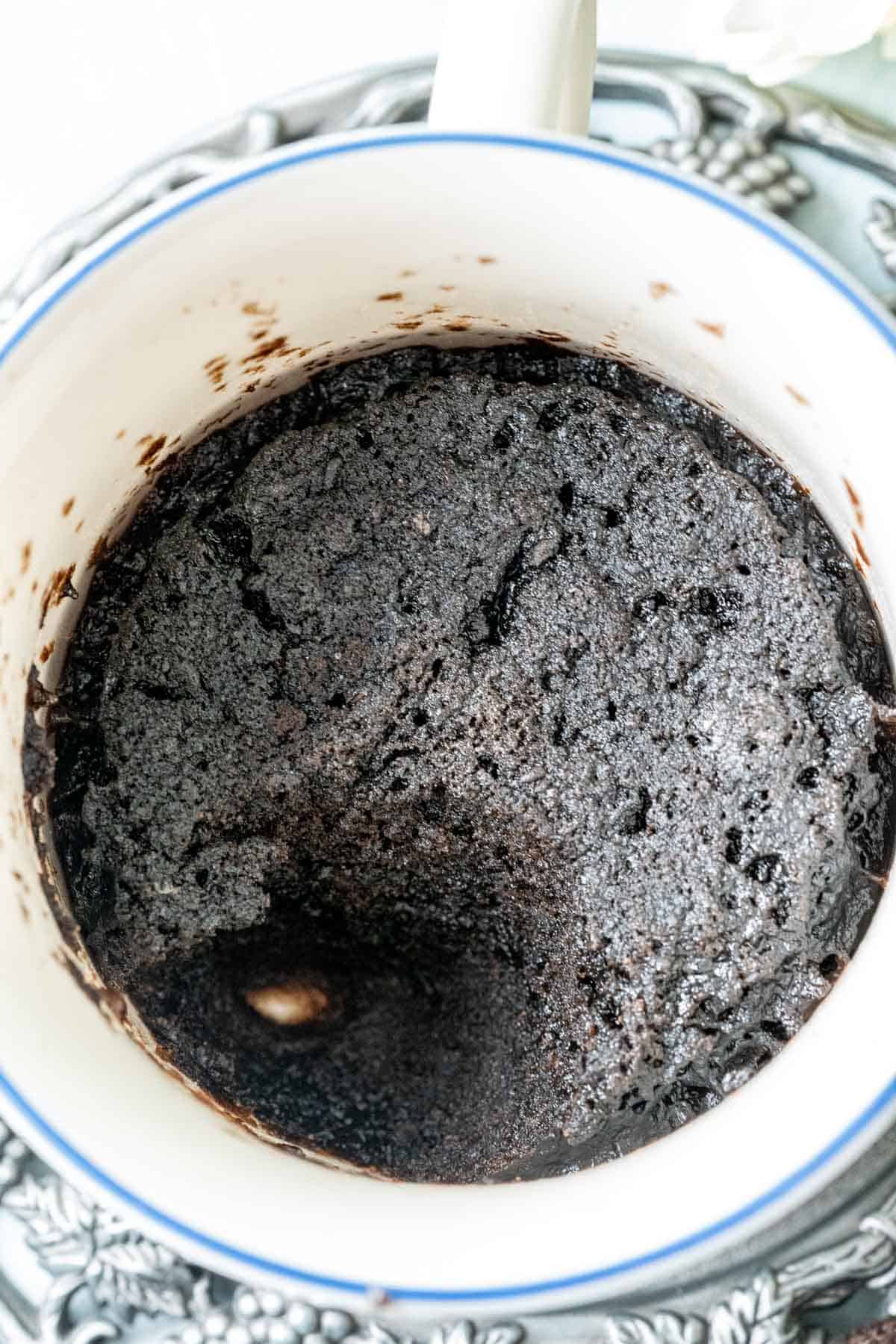 Oreo mug cake in a cup with a bite taken out of it.