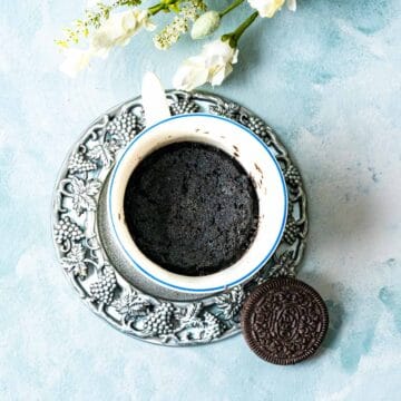 overhead shot of oreo cookies on a silver plate with a mug and cake inside.