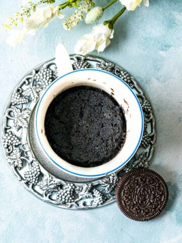 overhead shot of oreo cookies on a silver plate with a mug and cake inside.