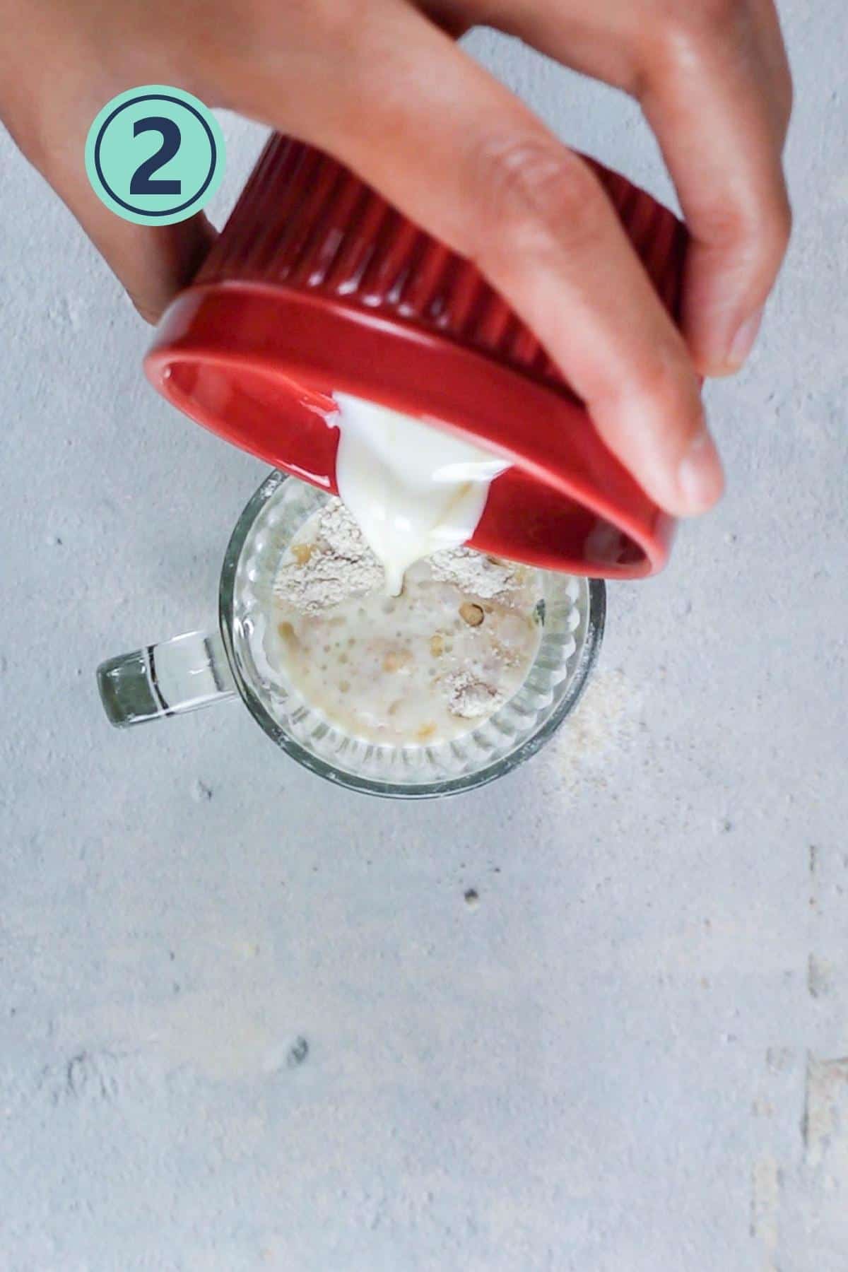 Adding wet ingredients to dry ingredients in a mug.