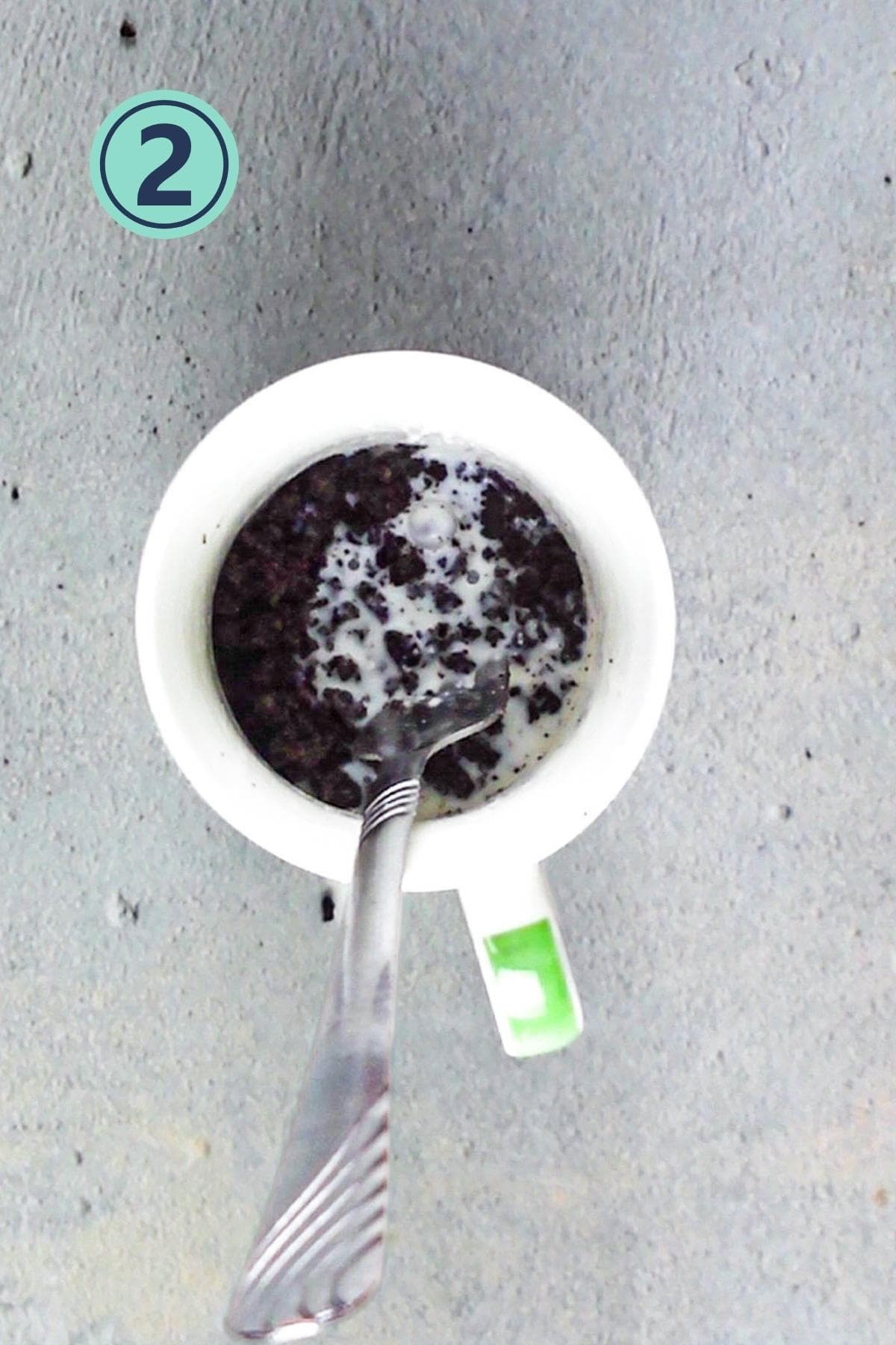 Adding milk to the cookies and mixing with a spoon.